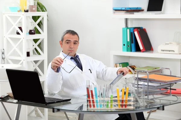 Cientista importante em seu escritório levantando sobrancelhas — Fotografia de Stock