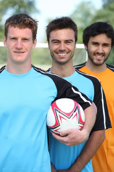 Drie lachende jonge voetballers — Stockfoto
