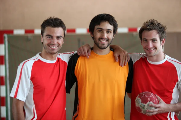 Трое молодых людей в помещении с мячом на руках — стоковое фото