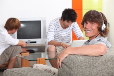 Three lads relaxing at home clipart