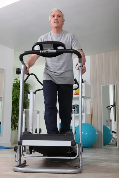 Middle-aged man on treadmill at home — Stock Photo, Image