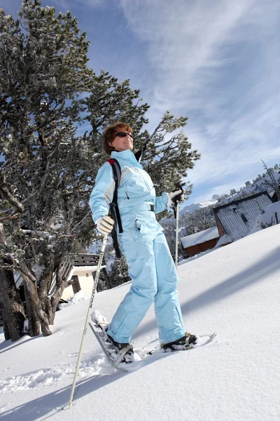 Полнометражный снимок лыжницы, идущей по снегу — стоковое фото