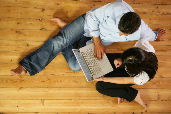 Couple in living-room with laptop computer, top-view — Stock Photo, Image