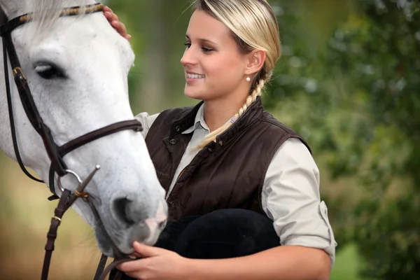 Jonge dame streelde haar paard — Stockfoto