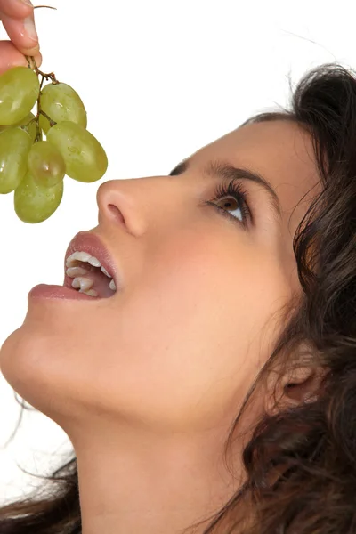 Mujer comiendo uvas seductoramente — Foto de Stock