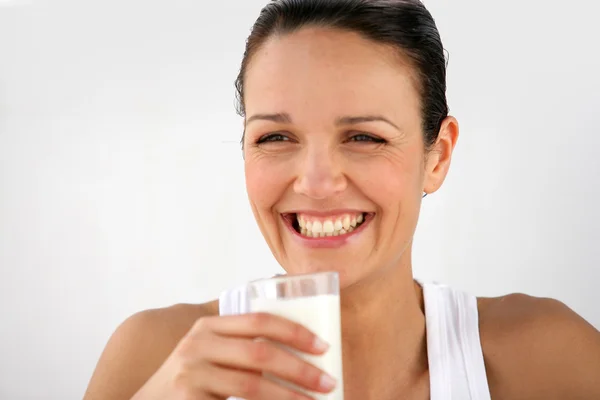 Веселая женщина пьет молоко — стоковое фото