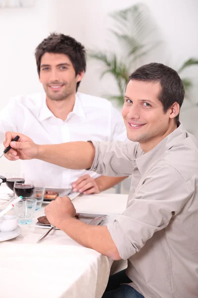 Два молодых человека обедают — стоковое фото