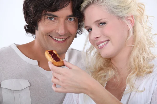 Frau füttert ihren Freund mit einem Keks — Stockfoto