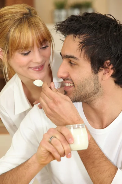 Мужчина кормит свою девушку йогуртом — стоковое фото