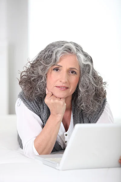 Retrato de uma mulher sênior na frente de um computador portátil — Fotografia de Stock