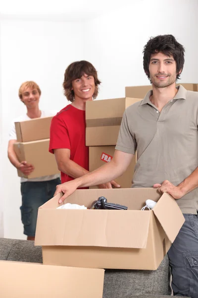 Mladí muži stěhovací krabice — Stock fotografie
