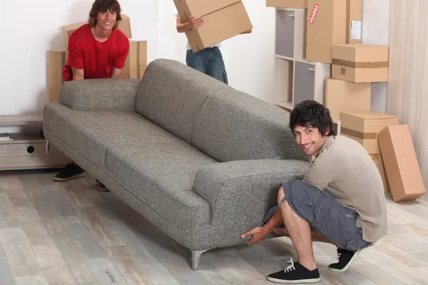 Foto de amigos moviendo un sofá —  Fotos de Stock