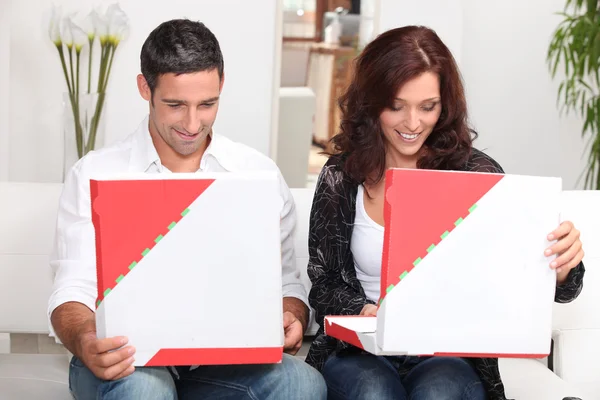A couple looking at their pizzas. — Stock Photo, Image