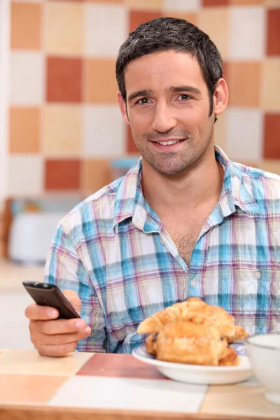 Hombre mensajes de texto durante el desayuno —  Fotos de Stock