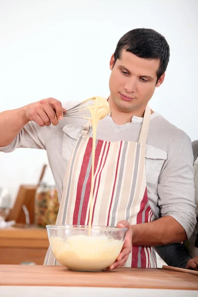 Young man wearing an apron and doing dough — Stock Photo, Image