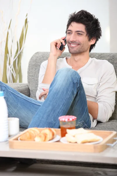 Muž mluví jeho mobilního telefonu před snídaní — Stock fotografie