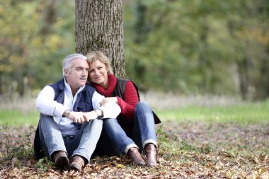 Couple sat by tree clipart