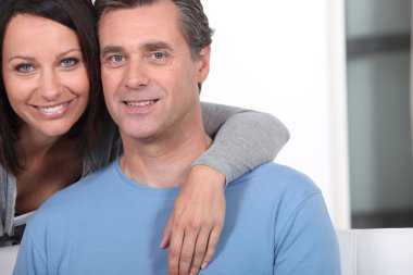 Woman hugging her husband from behind clipart