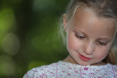 Little blonde girl watching down look amused clipart