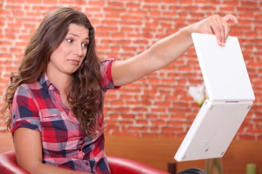 Woman disgusted by her laptop clipart