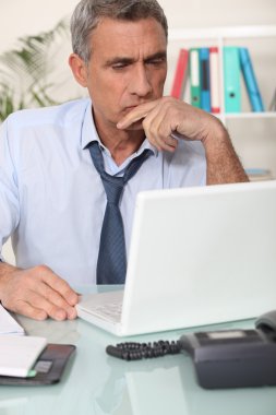 Grouchy man reading an email clipart