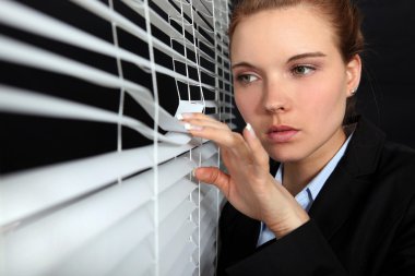 Woman looking through blinds clipart