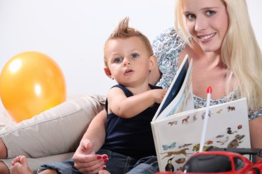 Mother reading to toddler clipart