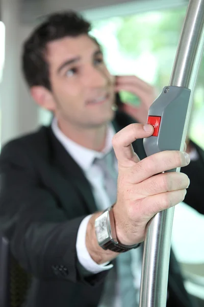 Επιχειρηματίας πιέζοντας κουμπί σε λεωφορείο — Φωτογραφία Αρχείου