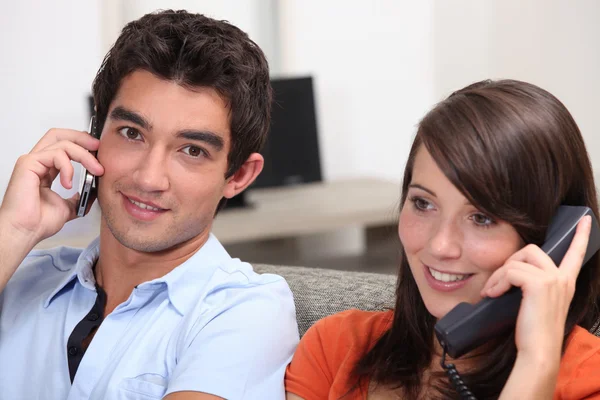 Young couple, both on the phone — Stock Photo, Image