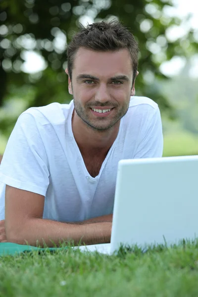 Człowiek korzysta z laptopa w parku — Zdjęcie stockowe