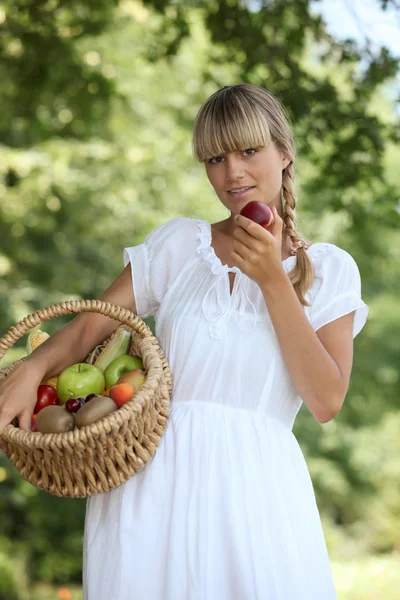 Summery woman with a basket of fruit — Stock Photo, Image