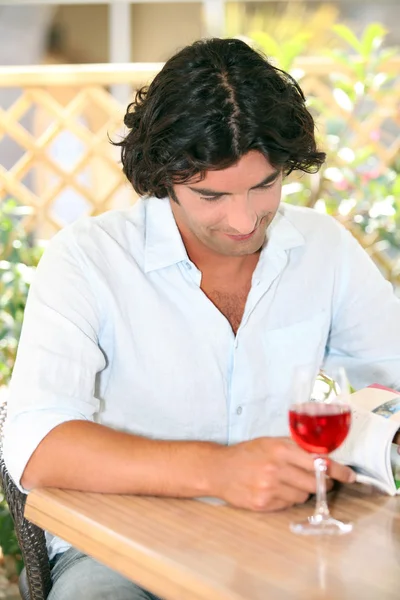 Człowiek czytanie rezygnować szklankę rose w promieniach słońca — Zdjęcie stockowe