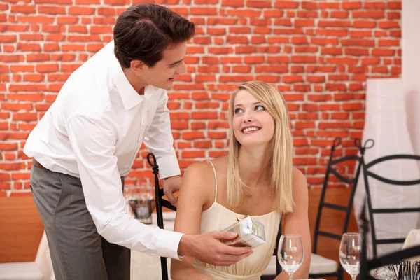 Człowiek dając prezent-niespodzianka dla kobiety w restauracji — Zdjęcie stockowe