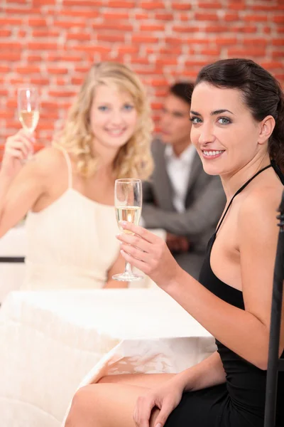 Two female friends drinking champagne in restaurant — Stock Photo, Image