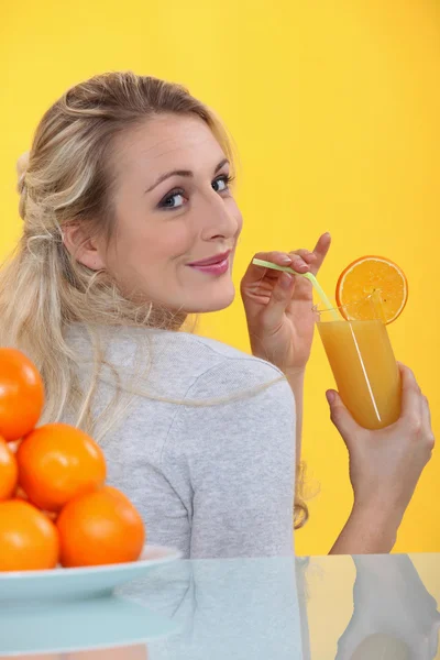 Блондинка пьет апельсиновый сок — стоковое фото