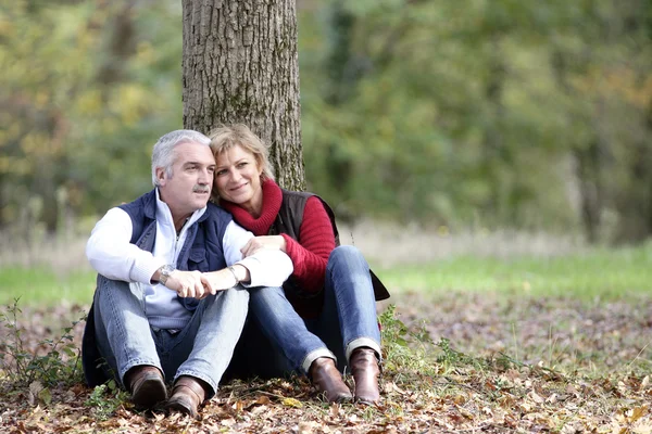 Couple assis près de l'arbre — Photo