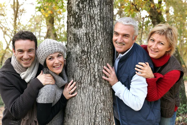 Vuxen familj runt ett träd — Stockfoto