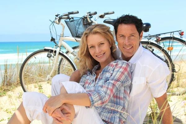 Casal na praia com bicicletas — Fotografia de Stock