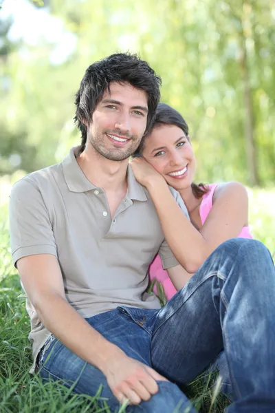 Para siedzi na trawie — Zdjęcie stockowe