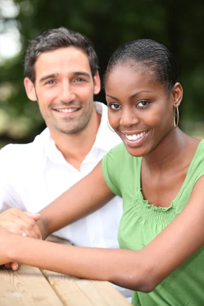 Mixed race couple sat at park table — Stock Photo, Image