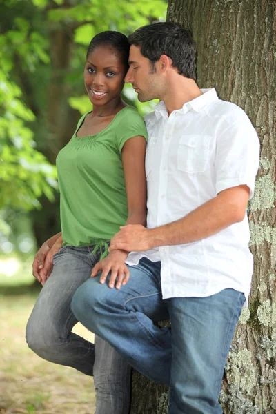 Um casal interracial em um parque . — Fotografia de Stock