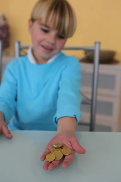 Маленький мальчик держит монеты — стоковое фото