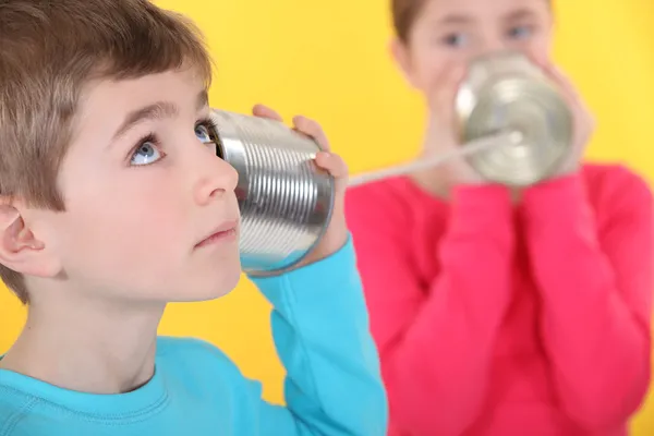 Two children communicating with tin can and string — Stock Photo, Image