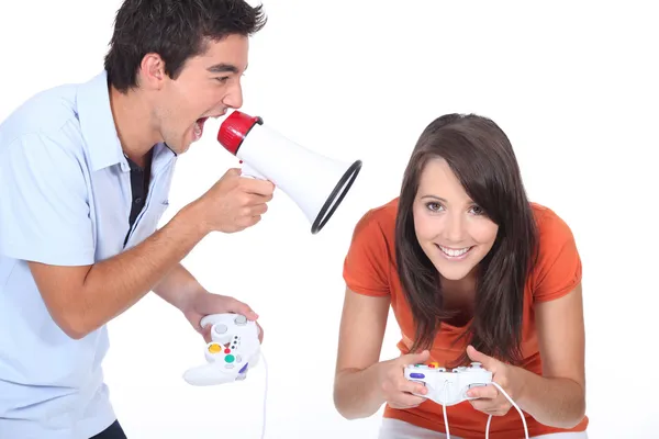Mężczyzna krzyczy do megafon, jak dziewczyna gra wideo gra — Zdjęcie stockowe