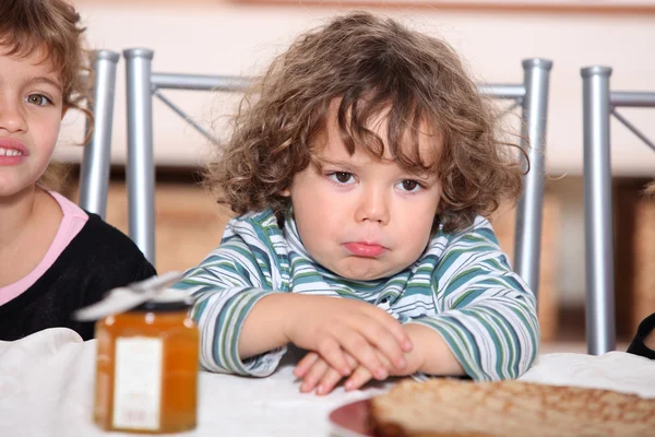 Grumpy criança esperando para comer panquecas — Fotografia de Stock