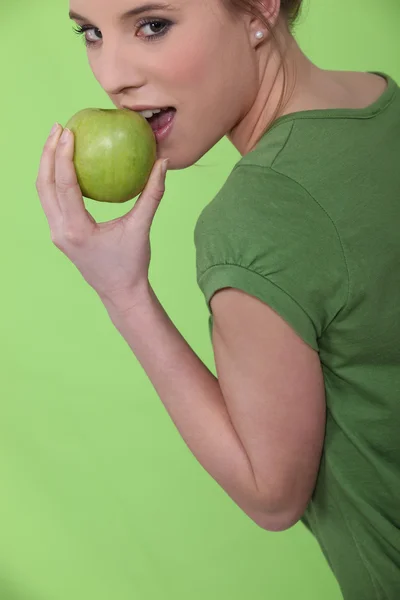 Frau beißt in grünen Apfel — Stockfoto
