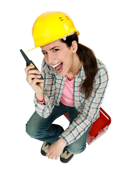 Female construction worker yelling into a walkie-talkie — Stock Photo, Image
