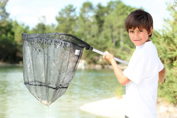 Jeune garçon avec un grand filet de pêche — Photo
