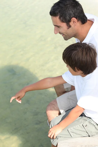 父亲和儿子坐在码头上 — 图库照片