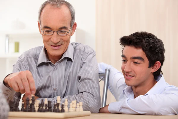 Старший играет в шахматы — стоковое фото